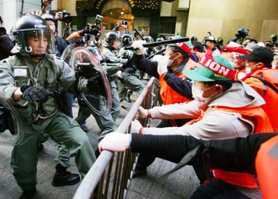 South Korean protester hits riot police with a baton seized from a policeman as they try to break through a police line on their way to the Hong Kong Convention and Exhibition Centre, venue for the sixth World Trade Organisation (WTO) Ministerial Conference in Hong Kong December 17, 2005. Hundreds of protesters battled past police lines on Saturday to reach the building where a meeting of world trade ministers is being held, a Reuters reporter said.