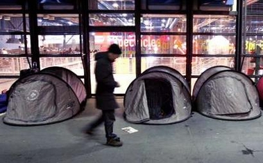 A man walks past the tents provided to homeless persons on a sidewalk near the Centre Pompidou modern art museum in Paris January 25, 2006.