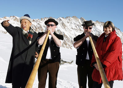 Chinese Foreign Minister Li Zhaoxing (L) and Swiss counterpart Micheline Calmy-Rey (R) flank two alphorn players blowing their instruments on top of Jungfraujoch, February 2, 2006. Li Zhaoxing journeyed to the Jungfrau mountain during an official visit to Switzerland.