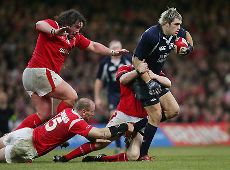 Scotland's Sean Lamont (R) is tackled by Wales' Duncan Jones (L), Gareth Thomas (2nd L) and Stephen Jones (2nd R) during their Six Nations rugby union match at the Millenium stadium, Cardiff, February 12, 2006.