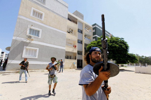 Rebel fighters scout for snipers in the final push to flush out Muammar Gadhafi's forces in Abu Salim in Tripoli August 25, 2011. UN to allow release of $1.5 bln frozen Libya funds